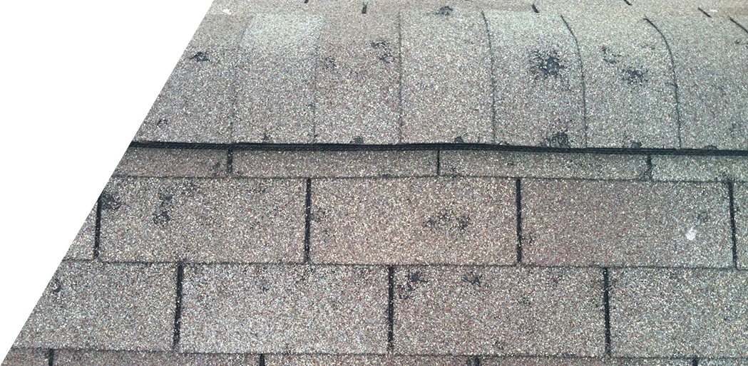 The image shows a close-up view of a worn asphalt shingle roof with visible signs of aging and wear.