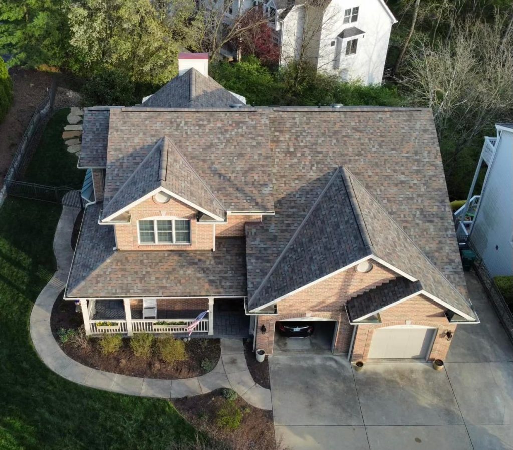 Aerial view of a residential house with a shingled roof, surrounded by greenery https://www.bbb.org/us/oh/cincinnati/profile/roofing-contractors/exterior-alliance-llc-0292-90019997