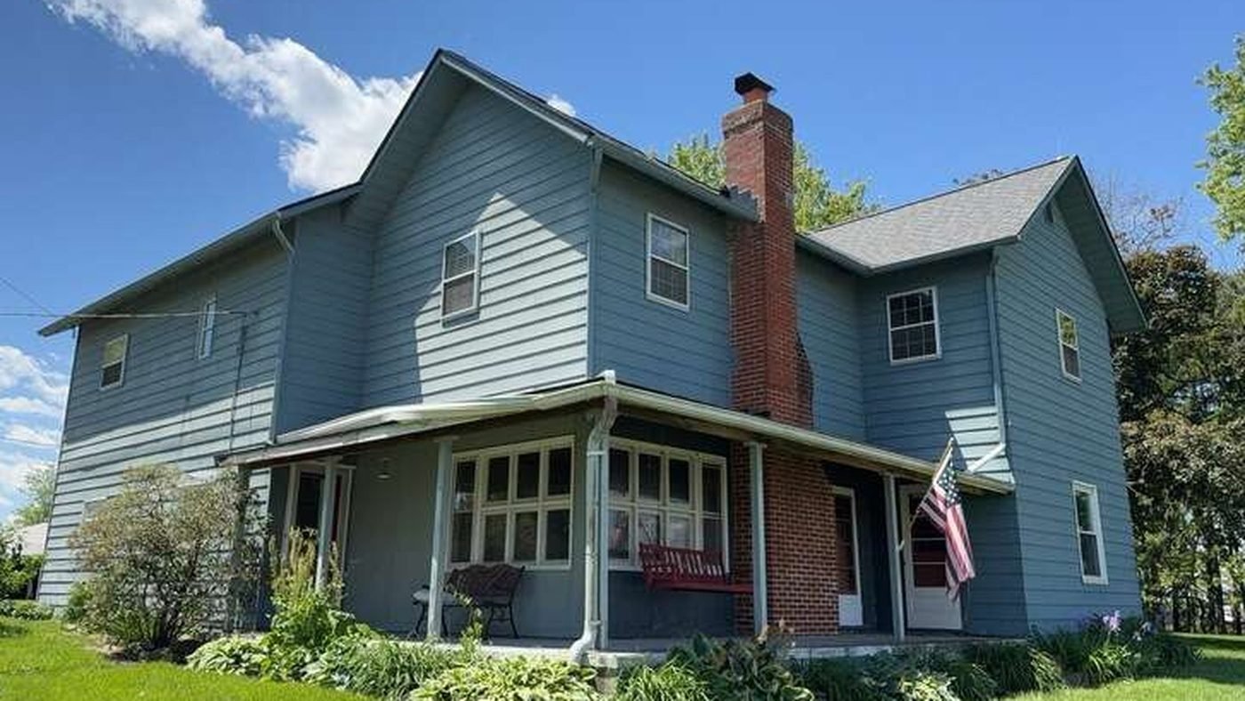 Before: weathered blue-grey aluminum siding